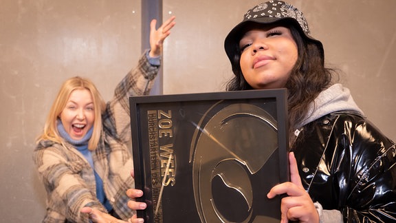 Zoe Wees hält stolz ihren New Music Award als Durchstarterin des Jahres in den Händen, Sissy von MDR SPUTNIK ist hyped im Hintergrund.